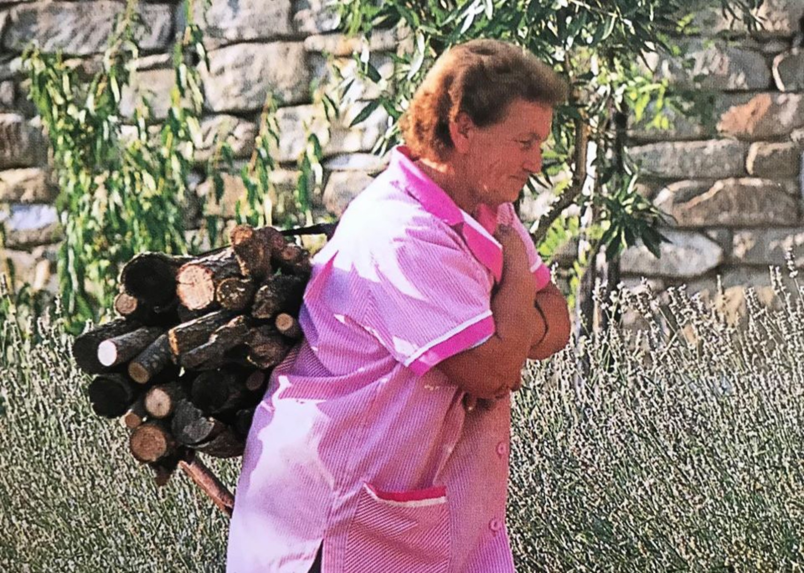 Dina Fragai carrying wood on her shoulders
